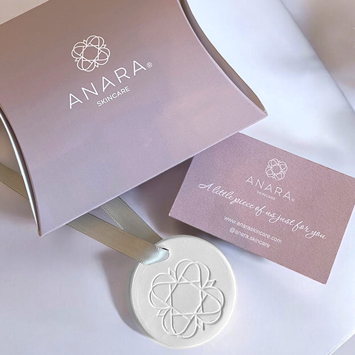 
                  
                    Anara Skincare emblem keepsake shown with pillow pack and card
                  
                