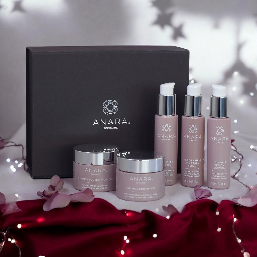 The Full Anara Skincare Range with Magnetic Gift Box with shadow stars in the background and burgundy material with twinkling lights